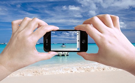 Tahun 2014 Akan Didominasi Smartphone Berkamera Super 1 Close up photo of a female tourist taking photos of a beautiful beach in The Bahamas with her iPhone 4 camera
