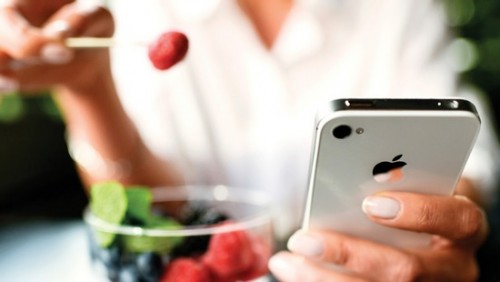 Apple Siapkan iOS 9 Khusus untuk Perangkat Lawas 1 Woman eating fruits dessert with iPhone 4s in hands